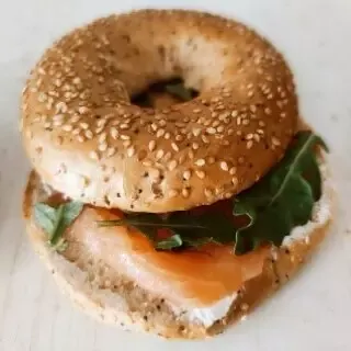 Bagel de salmón ahumado, escarola frisée y crema de queso con nuez
