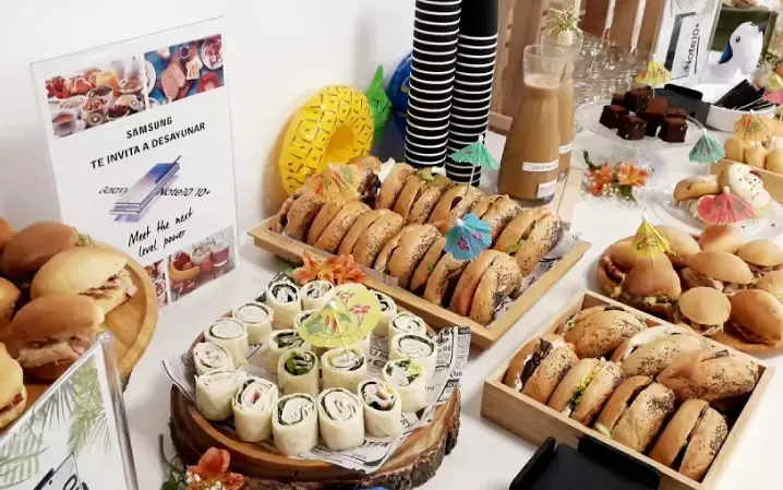 Mesa de desayuno de empresa con wraps y sándwiches