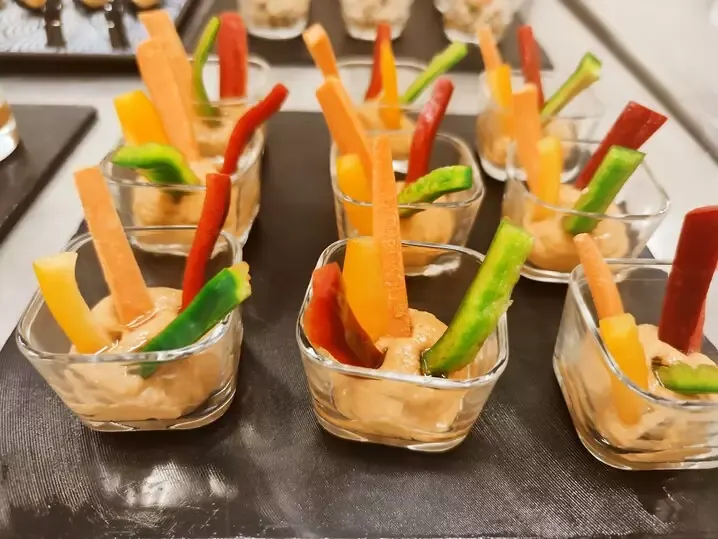 Mesa de evento con brownies, sándwiches y vasitos