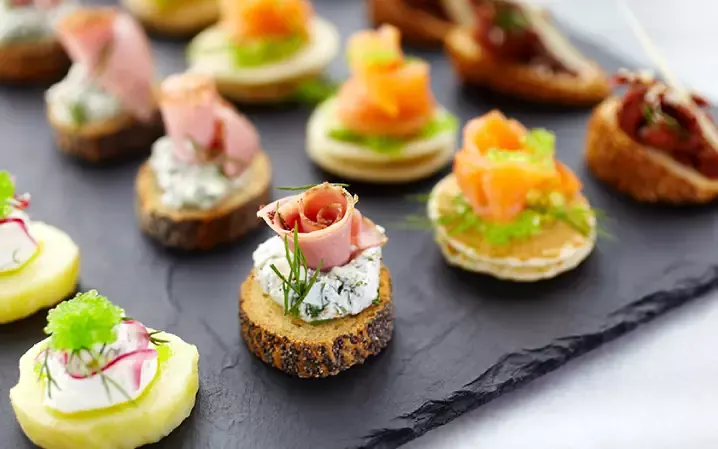 Canapés variados sobre pizarra negra