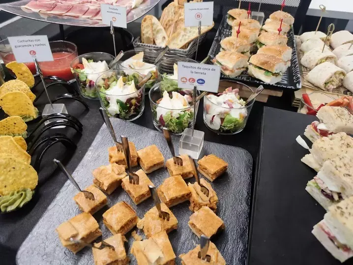 Mesa de finger food con sándwiches y bocados