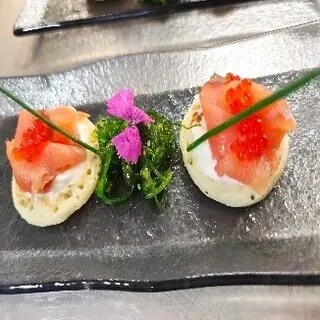 Mini blinis con lascas de salmón ahumado y crema de queso