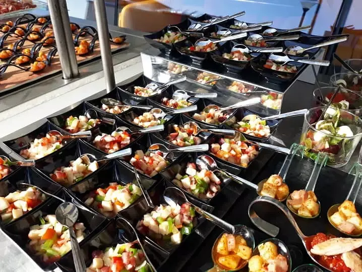 Buffet con cucharitas de aperitivo sobre mantel negro