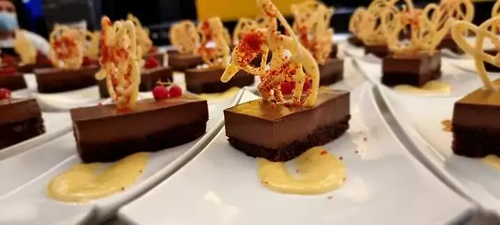 Postre de chocolate con teja crujiente en plato blanco